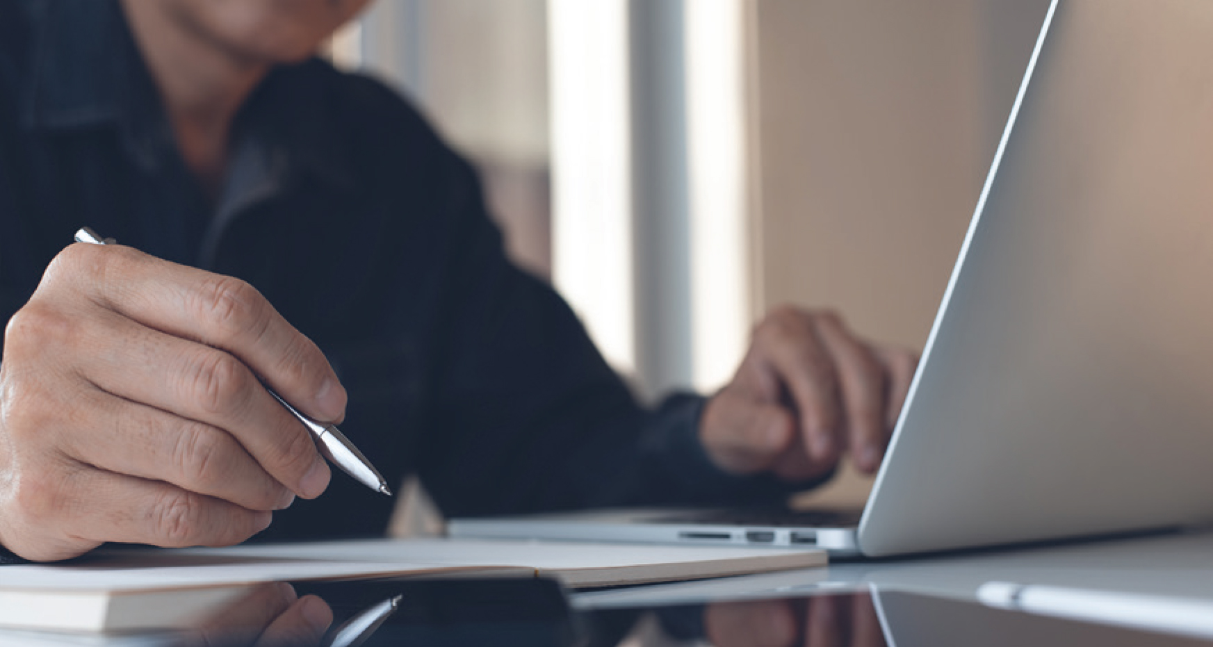 Person with pen and laptop