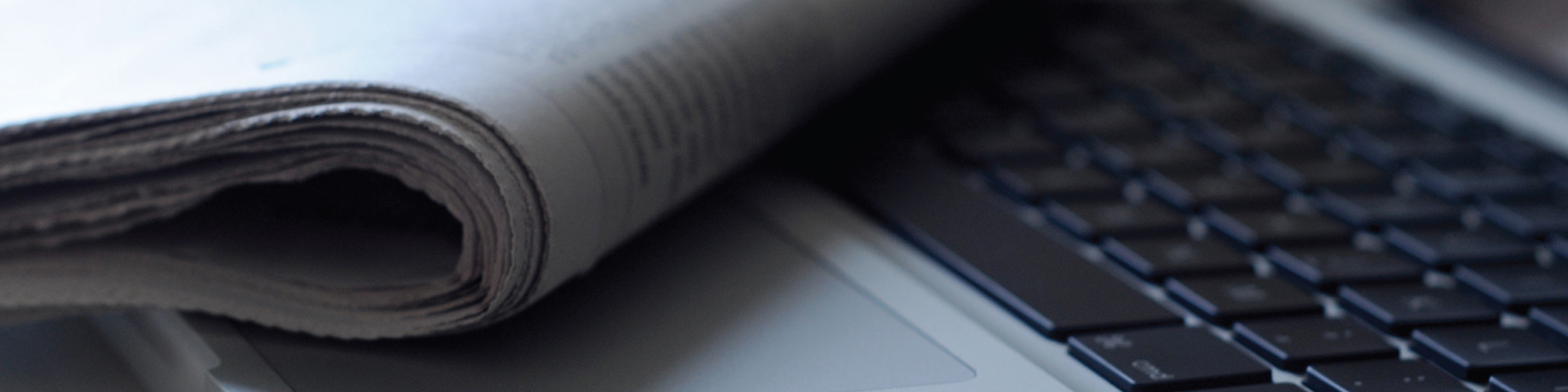 Folded newspaper and laptop