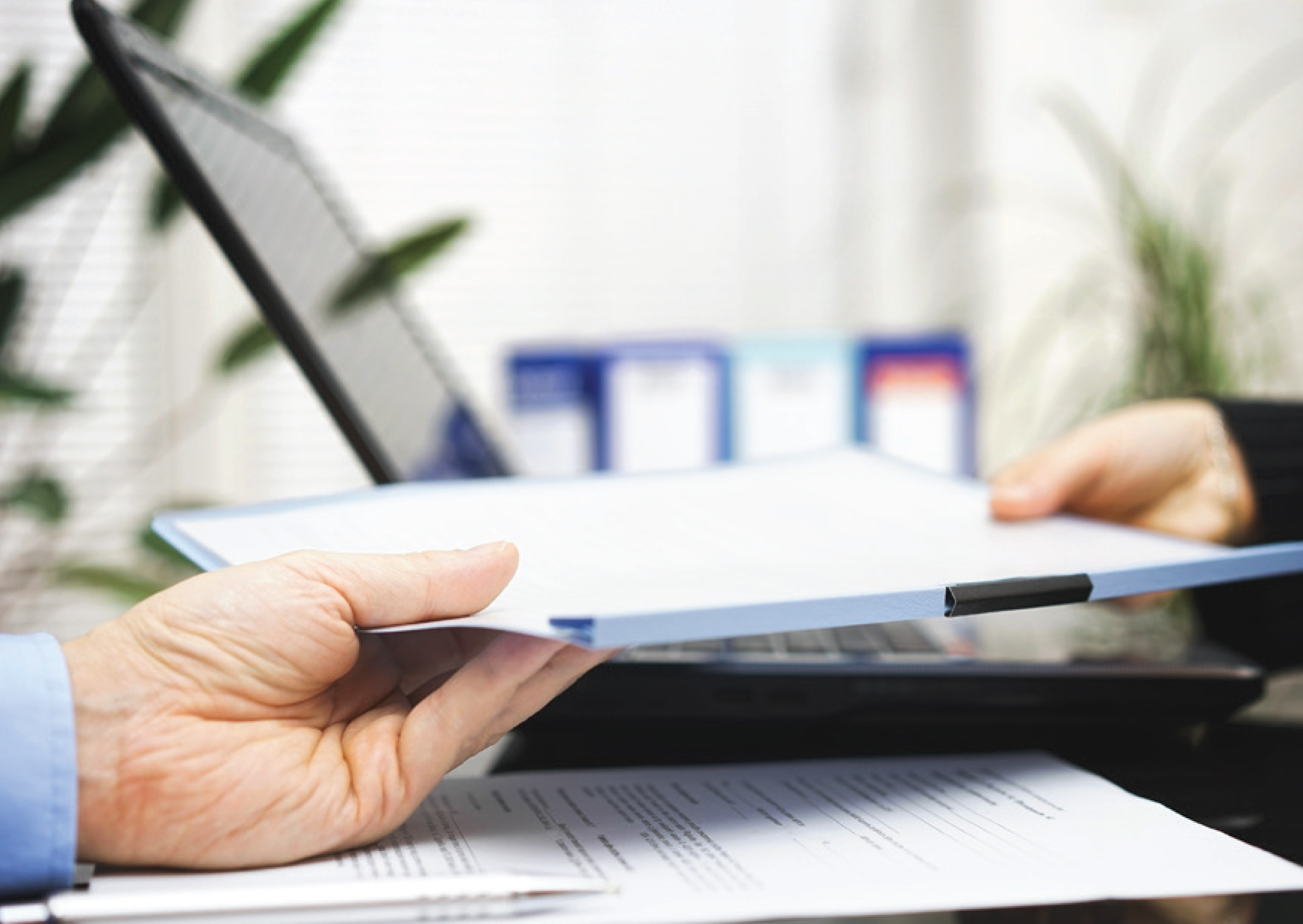 Person handing a document to another person