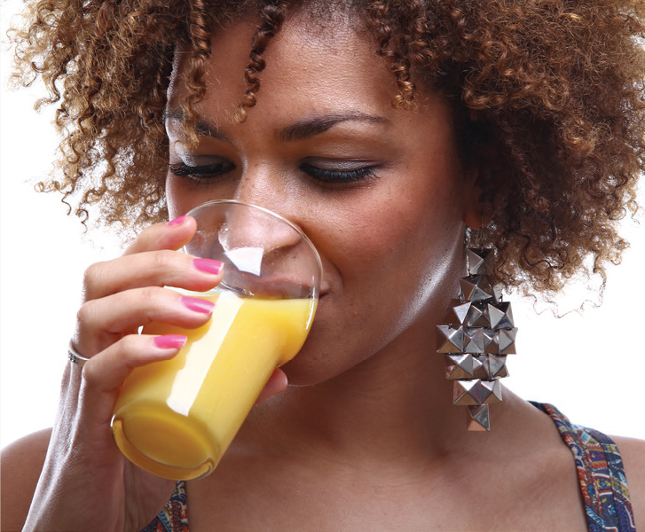 Image of a lady drinking a glass of orange juice